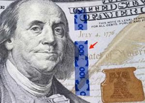 Showing blue security ribbon on the $100 bill.