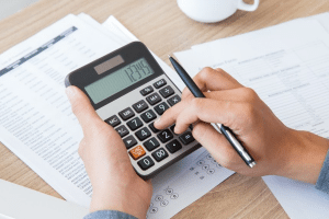 person using a calculator to do taxes