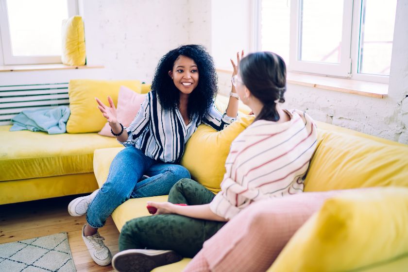 Two young women having discussion in the living room