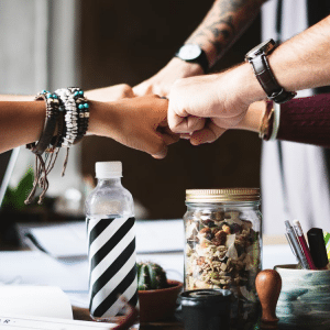 Un team di persone in cerchio che si toccano i pugni