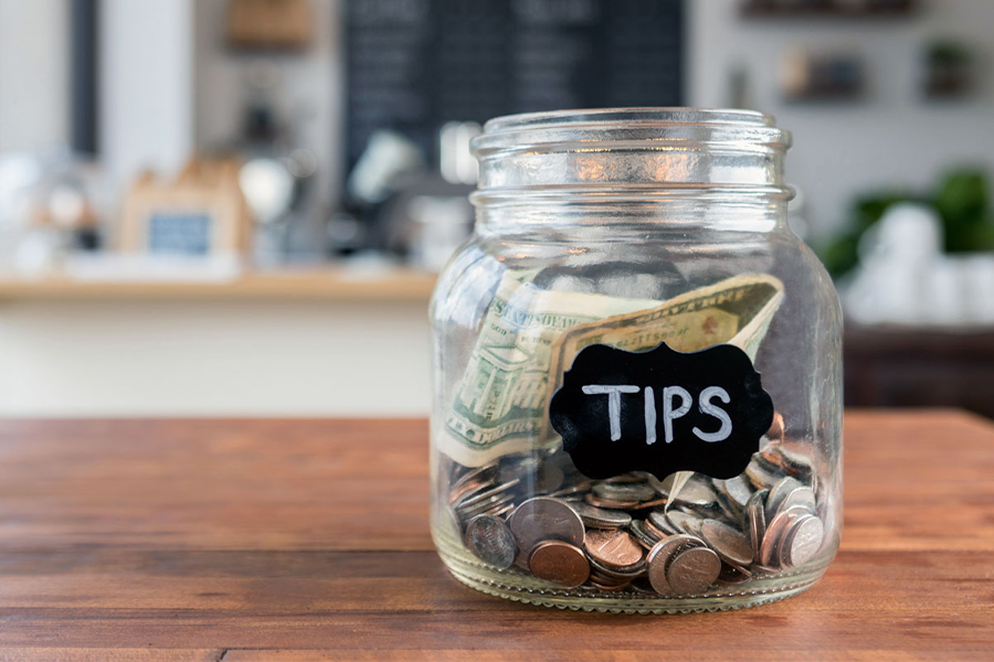 Glass jar with coins and inscription tips