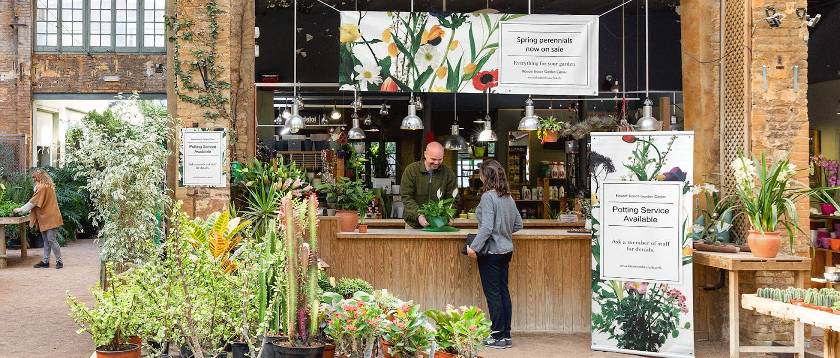 Flower shop with business banners and signs on its store front.