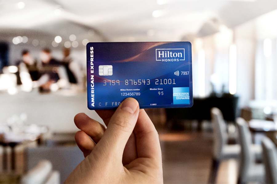 Hand holding a Hilton Honors American Express Business Card.