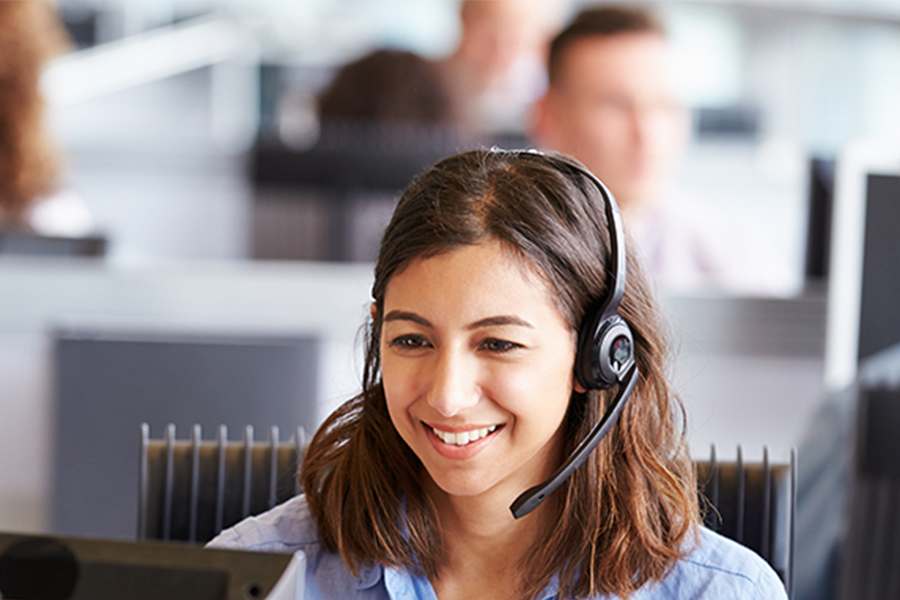 The female call center agent smilingly talked to the client.