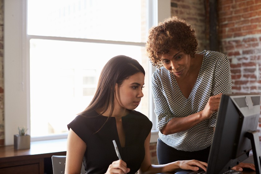 Women employees working together on the computer.