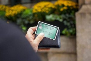 Guy holding American Express Business Green Rewards Card.