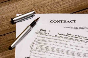 A pen and a W-9 form contract.