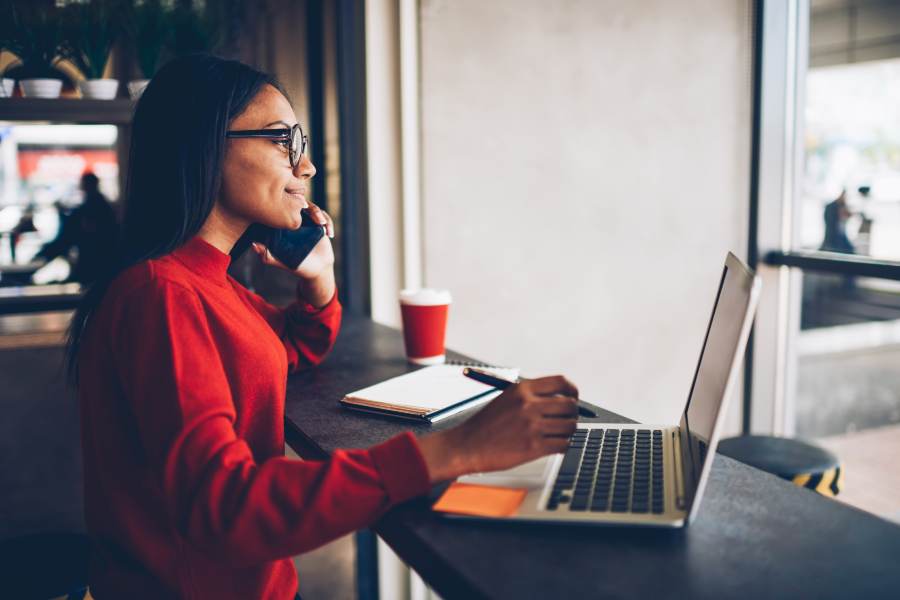 Woman on the phone while working on her laptop