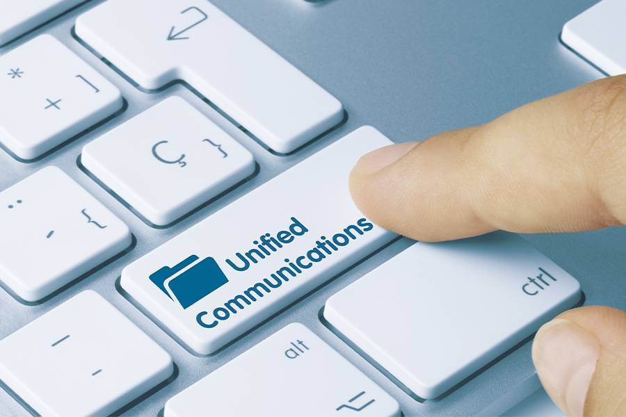 Finger pressing the enter key with the text "Unified Communication" on it.