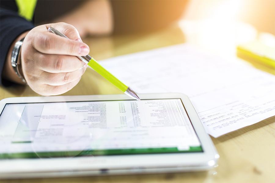 Close-up shot of a hand holding a pen searching file on a tablet.