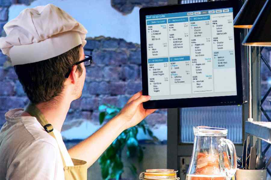 A chef checking the kitchen display system.