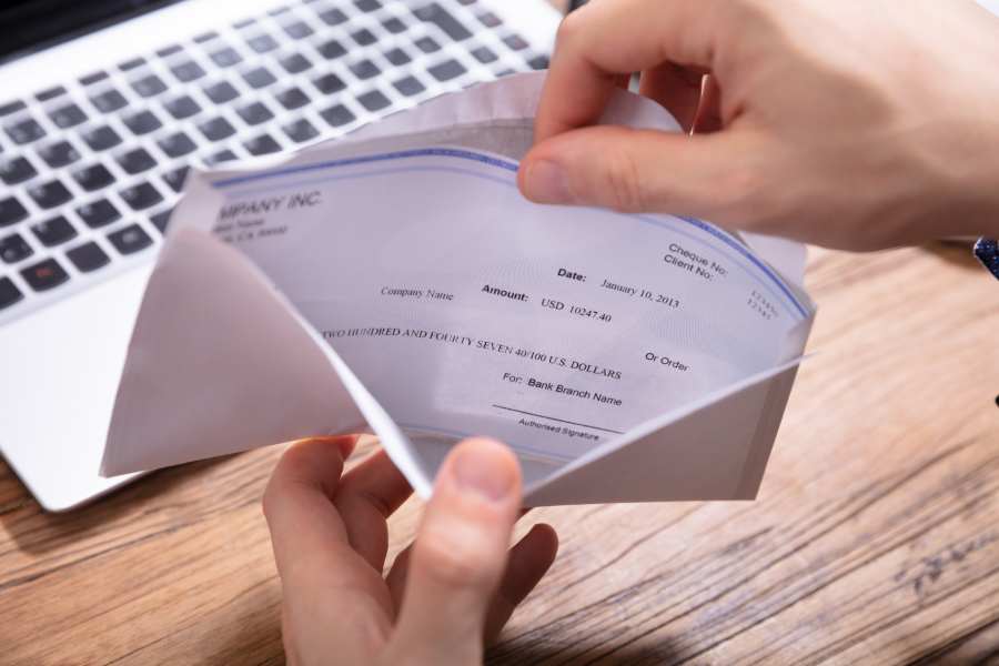 Showing a person checking on payroll inside an envelope.