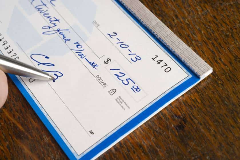 image of man signing on cheque