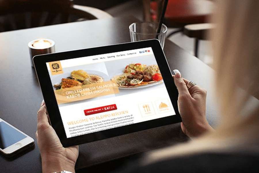 Woman browsing a restaurant website on a tablet.