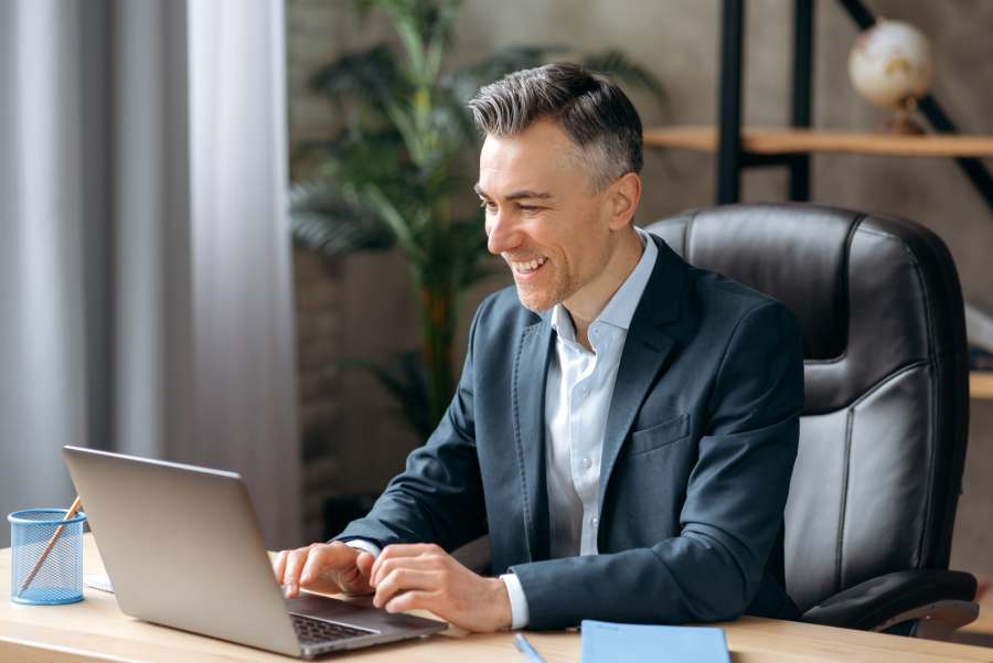 businessman happily working on his laptop