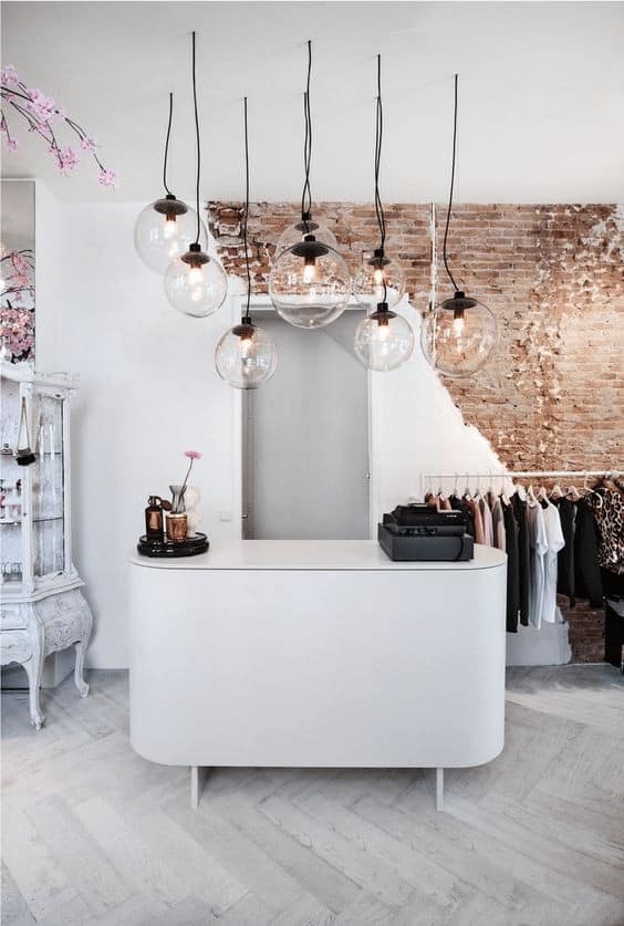 A boutique using a decorative pendant lights to create task lighting over its cash wrap.