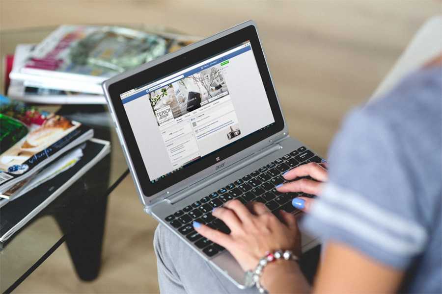 woman browsing facebook on laptop