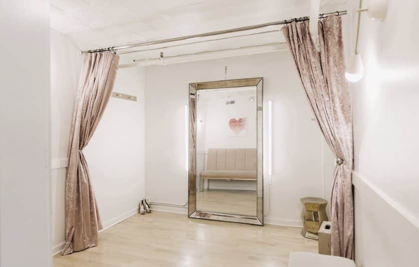 A spacious fitting room gives customers plenty of space to try on their pieces and see themselves.