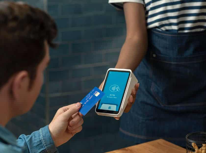 A man paying using credit card on a Square Terminal.