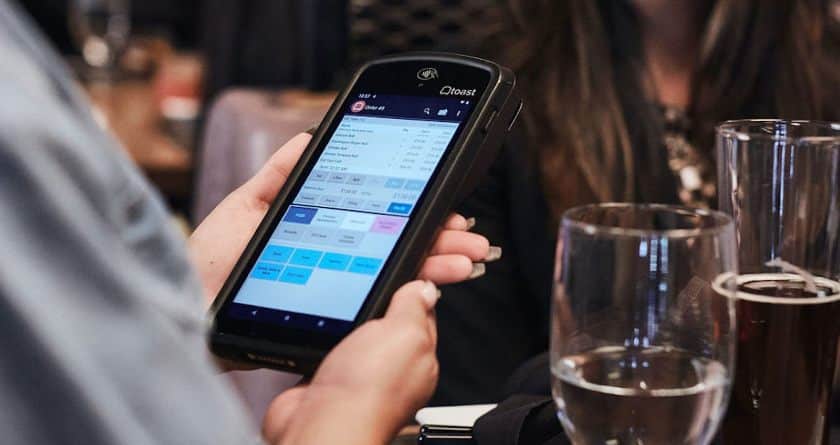 A woman holding Toast Go 2 handheld device.