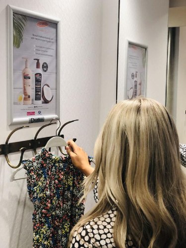 An ad for a new lotion hangs above outfit holder.