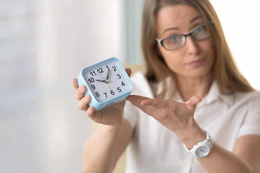 Woman holding a clock.