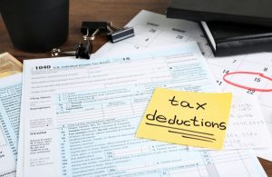 Form 1040 and Tax Deductions written on a post-it