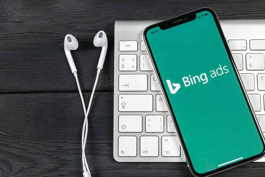 cellphone with Bing Ads on screen, headset and keyboard