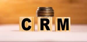 The word CRM on wooden cubes with coins.