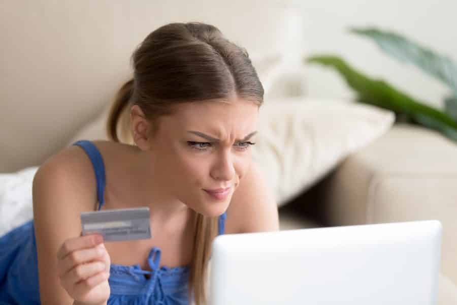 Confused young woman having problem with blocked credit card
