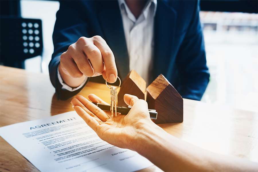 Real estate agents give keys to clients after signing the contract