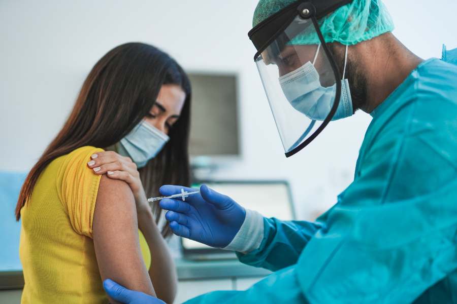 Male doctor or nurse vaccine to a patient's shoulder