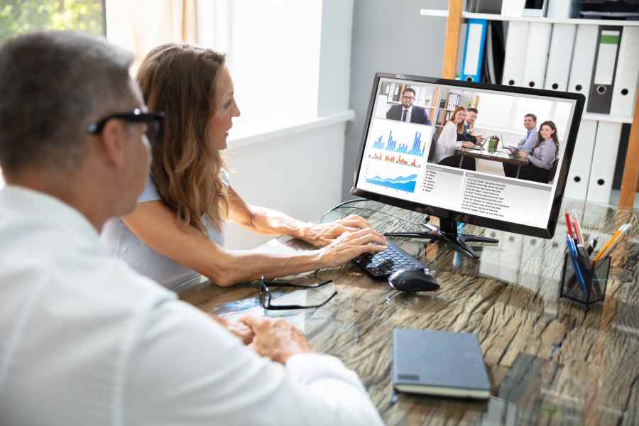Businessman having online video conference with his team in his office.