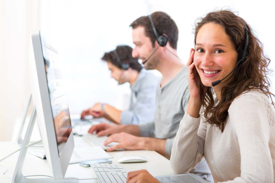 A woman working as a customer support operator accompanied by her team.