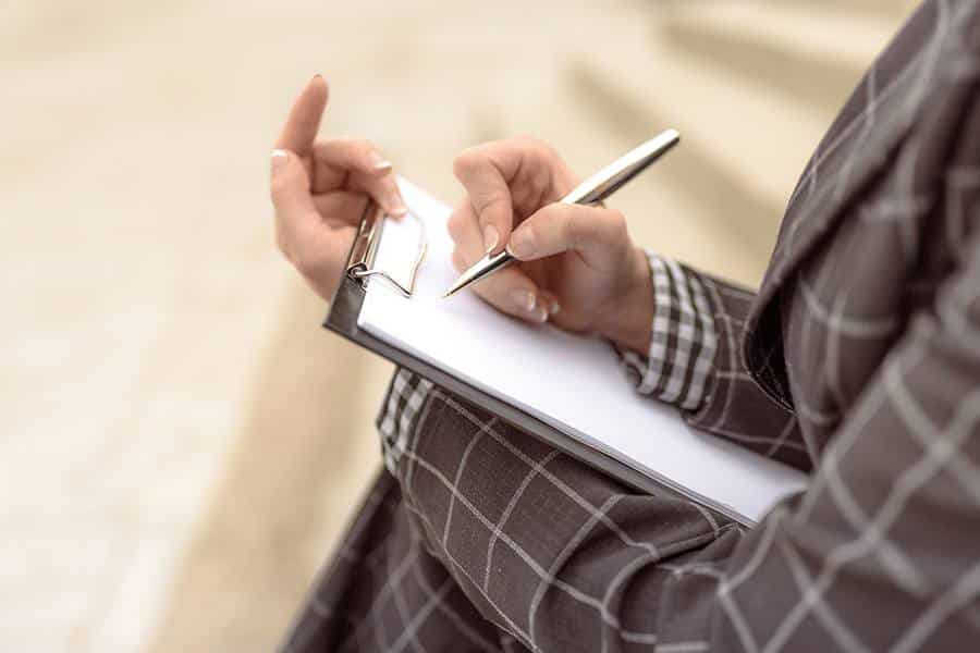 A woman holding a clipboard and a pen.