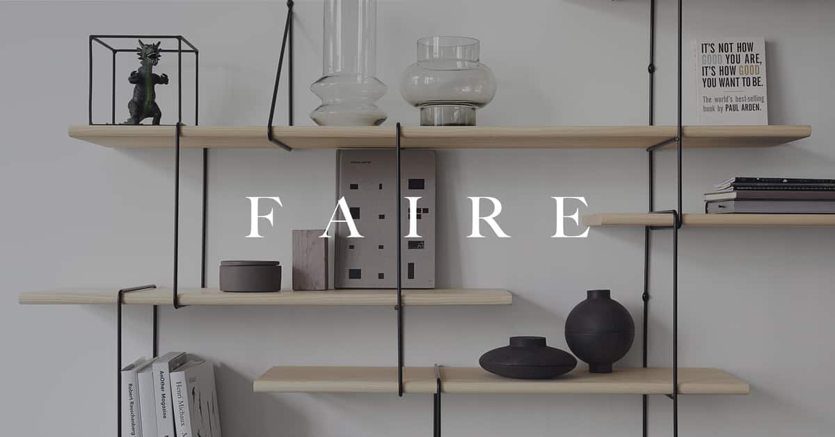 Faire home page with modern shelves on beige wall with decorative vases, lamp and books in the background.