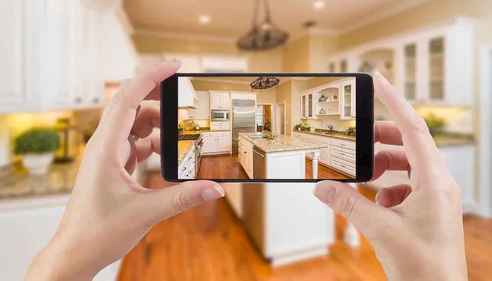Screenshot of Holding Smart Phone Displaying Photo of Kitchen 