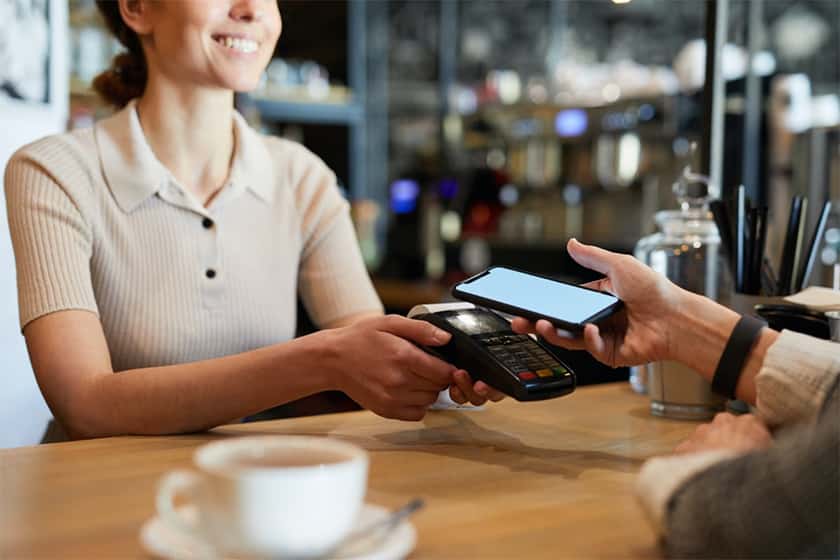 paying bill through smartphone using NFC technology in cafe