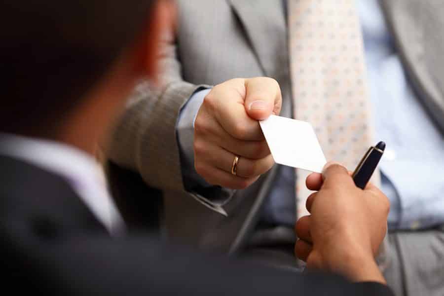 A businessman giving his business card to another businessman.
