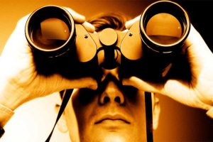 A man looking through binoculars.