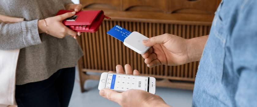 Showing transaction using smartphone with square card reader.