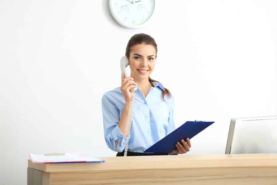 Young female receptionist working in the office.