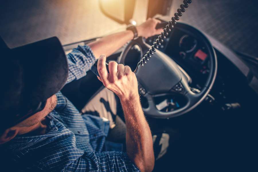 A Truck Driver Making Conversation with Other Truck Drivers Through CB Radio.