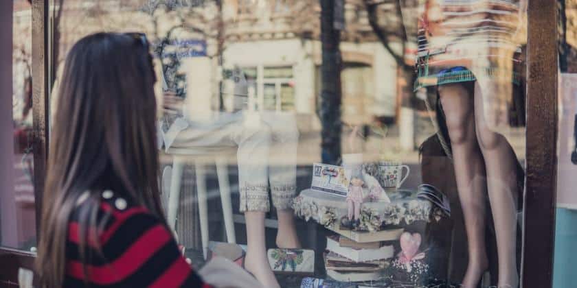 A woman looking at a storefront.