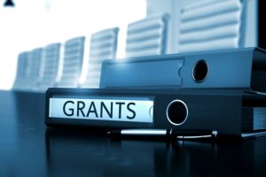 A black folder with documents labeled as "GRANTS".