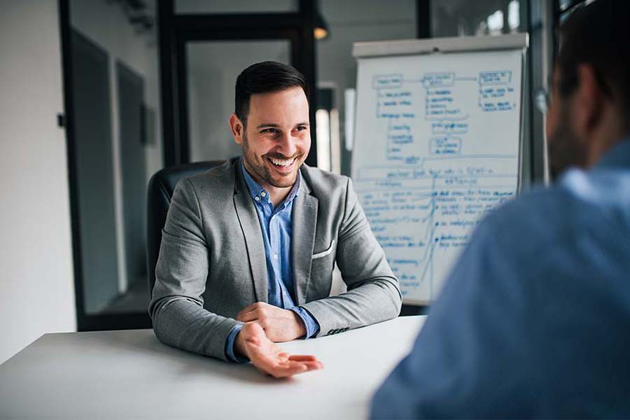 Sales manager happily talking to his colleague.