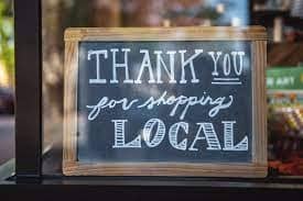 A business sign that says ‘Thank you for shopping local'.