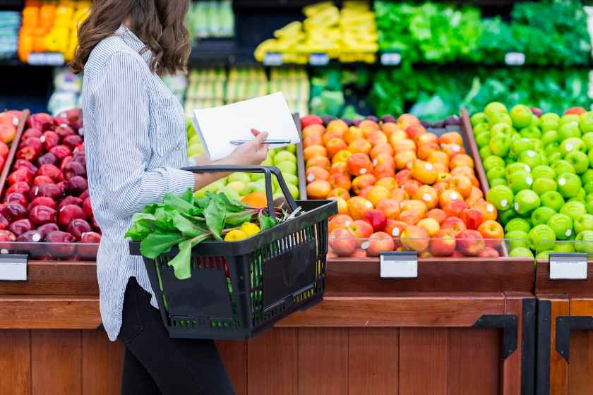 Showing a woman buying groceries.