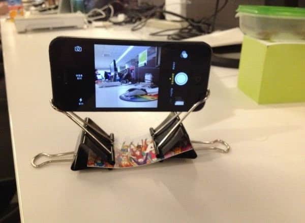 Fastening two binder clips to a strip of paper creates a simple and effective phone stand.