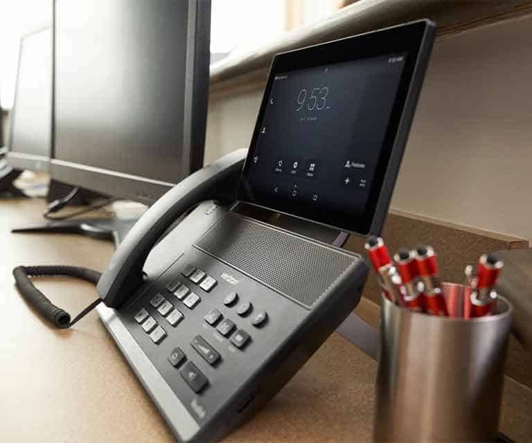 Telephone devices at office desk for customer service support.